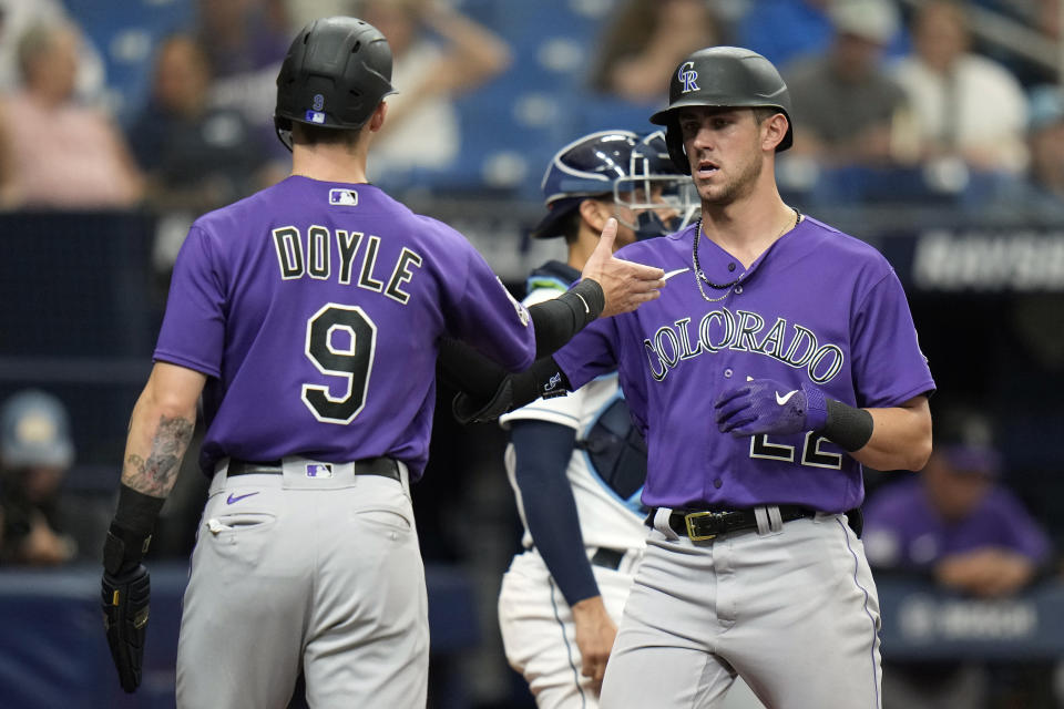 Colorado Rockies' Nolan Jones (22) celebrates his three-run home run off Tampa Bay Rays relief pitcher Erasmo Ramirez with Brenton Doyle (9) during the fifth inning of a baseball game Thursday, Aug. 24, 2023, in St. Petersburg, Fla. (AP Photo/Chris O'Meara)