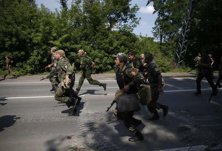 Pro-Russian separatist fighters from the so-called Battalion Vostok (East) run into position at a checkpoint in the eastern Ukrainian city of Donetsk, July 10, 2014. REUTERS/Maxim Zmeyev
