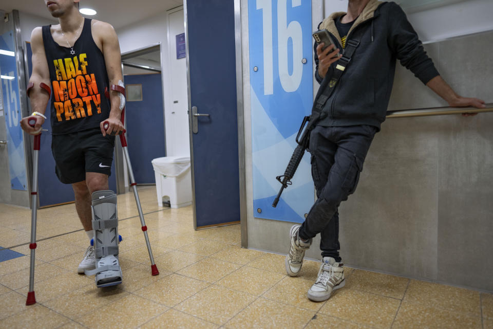 An Israeli soldier wounded in the war with Hamas walks with crutches in the rehabilitation division of Sheba hospital in Ramat Gan, Israel, Monday, Dec. 18, 2023. (AP Photo/Oded Balilty)