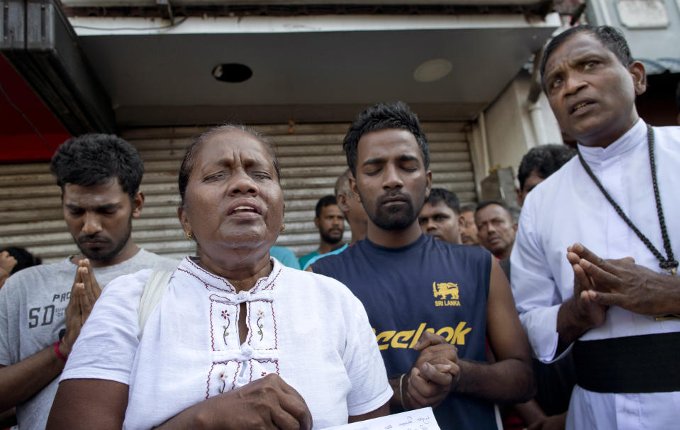 People pray during a nationwide three-minutes silence as a tribute to Easter Sunday attack victims in Colombo, Sri Lanka, Tuesday, April 23, 2019. Easter Sunday bombings of churches, luxury hotels and other sites was Sri Lanka's deadliest violence since a devastating civil war in the South Asian island nation ended a decade ago. (AP Photo/Gemunu Amarasinghe)