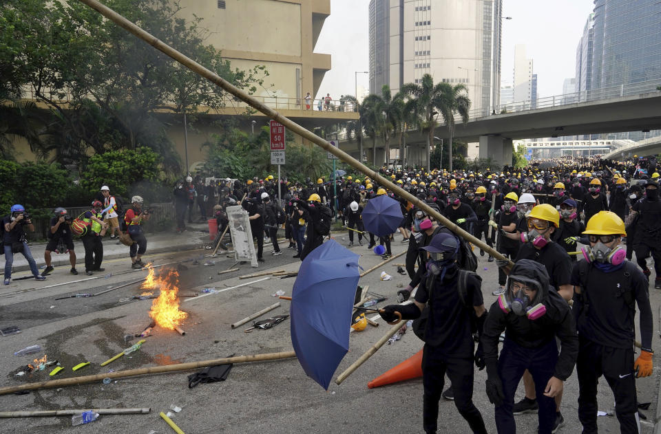 Demonstrators wield umbrellas and bamboo poles during a protest in Hong Kong, Saturday, Aug. 24, 2019. Chinese police said Saturday they released an employee at the British Consulate in Hong Kong as the city's pro-democracy protesters took to the streets again, this time to call for the removal of "smart lampposts" that raised fears of stepped-up surveillance. (AP Photo/Vincent Yu)