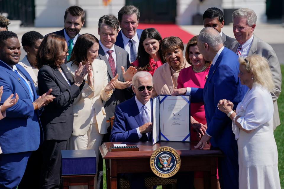 President Joe Biden holds the "CHIPS and Science Act of 2022" after signing it during a ceremony on the South Lawn of the White House, Tuesday, Aug. 9, 2022, in Washington. (AP Photo/Evan Vucci)