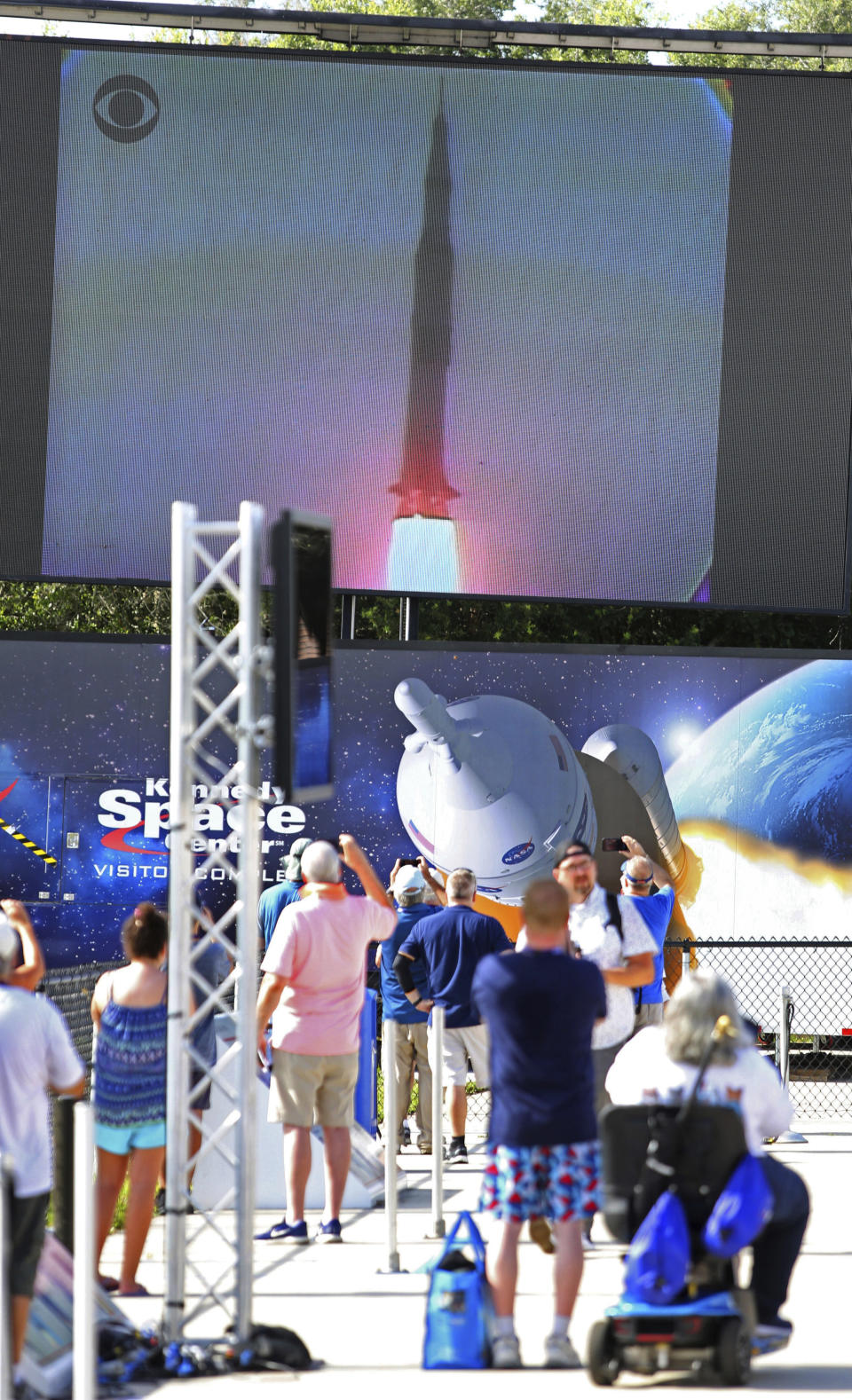 People watch lift-off during the Apollo 11 Launch Flashback, broadcast by CBS at the Kennedy Space Center's Apollo/Saturn V exhibit, Tuesday July 16, 2019. Guests viewed a rebroadcast of the 1969 launch from the grandstands at the Banana Creek viewing area to commemorate the launch of the Saturn V rocket and the Apollo 11 crew 50 years ago. (Joe Burbank/Orlando Sentinel via AP)