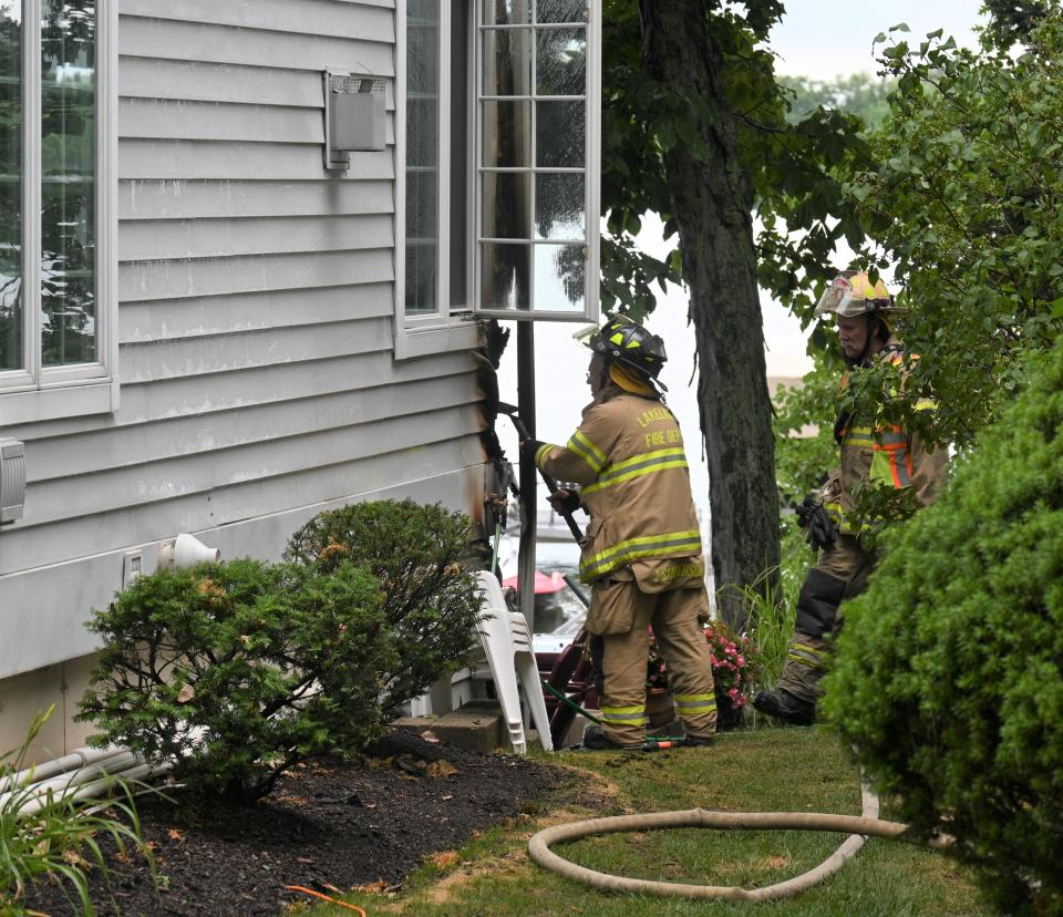 Lakeland firefighters peel away siding to get to fire caused by lightning strike on Coldwater Lake.