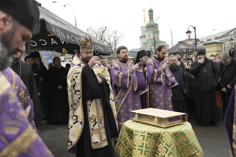 Priests of Ukrainian Orthodox Church pray with their supporters after resisting a government order to leave the Kyiv Pechersk Lavra monastery complex in Kyiv, Ukraine, Saturday, April 1, 2023. In a bitter dispute over a famed Orthodox monastery, Ukraine's top security agency notified a leading priest on Saturday that he was suspected of justifying Russia's aggression, a criminal offense, Metropolitan Pavel, the abbot of the Kyiv-Pechersk Lavra monastery, Ukraine's most revered Orthodox site, has resisted the authorities' order to vacate the complex. Earlier in the week, he cursed Ukrainian President Volodymyr Zelenskyy, threatening him with damnation. (AP Photo/Roman Hrytsyna)