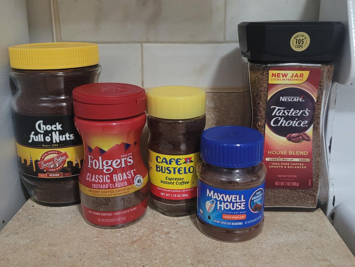 five brands of instant coffee sitting next to each other on a kitchen counter