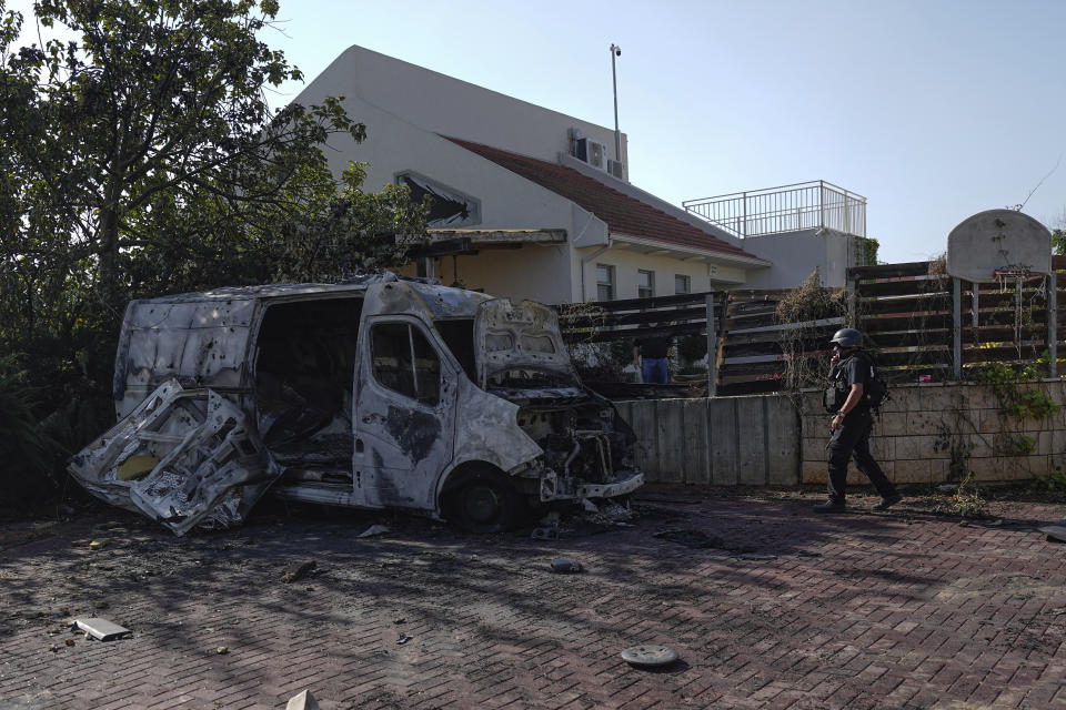 Israeli security personal inspect a site hit by a rocket fired from the Gaza Strip, In a community near the Israeli-Gaza border, southern Israel on Friday, Dec. 1, 2023. (AP Photo/Ariel Schalit)