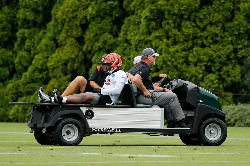 Cincinnati Bengals halfback Elijah Holyfield (36) is checked by the training staff after injuring his right knee during the first day of preseason training camp at the Paul Brown Stadium training facility in downtown Cincinnati on Wednesday, July 27, 2022.
