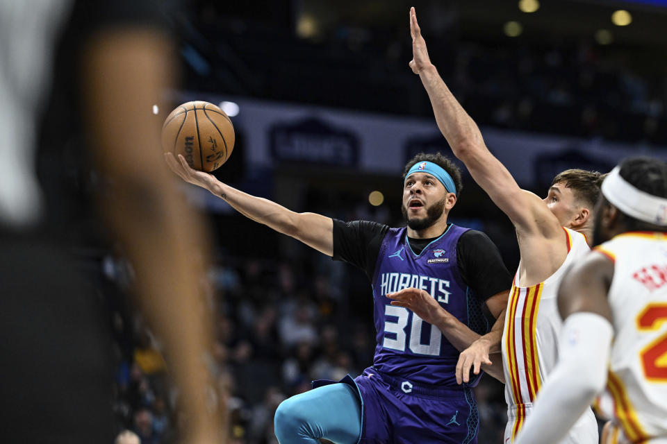 Charlotte Hornets guard Seth Curry (30) drives to the basket against Atlanta Hawks guard Bogdan Bogdanovic during the first half of an NBA basketball game Wednesday, Feb. 14, 2024, in Charlotte, N.C. (AP Photo/Matt Kelley)