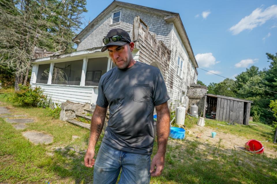 Frank Lemaire Jr. stands outside his boyhood home in West Greenwich. His family is among a handful still living as renters on land taken by the state for the Big River Reservoir.