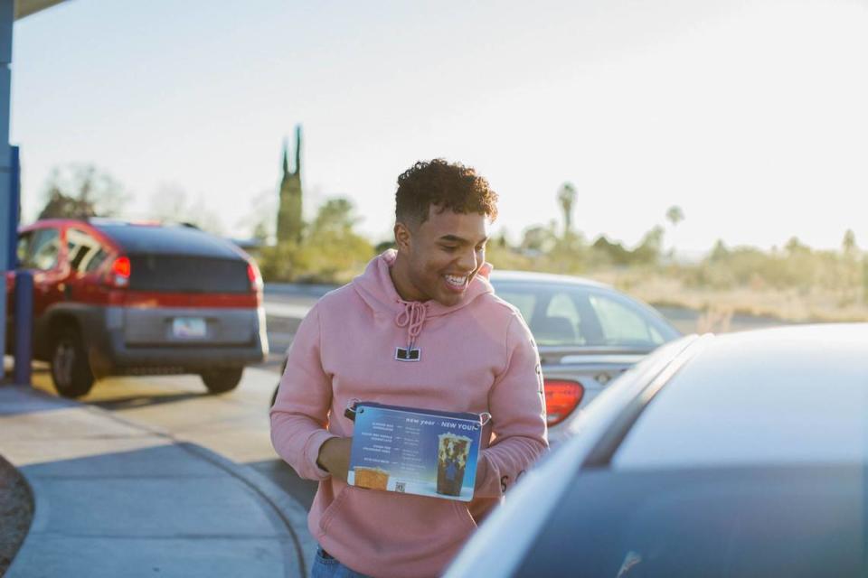 A “broista” takes an order at a Dutch Bros Coffee drive-thru, where passionate fans line up for coffee. Provided