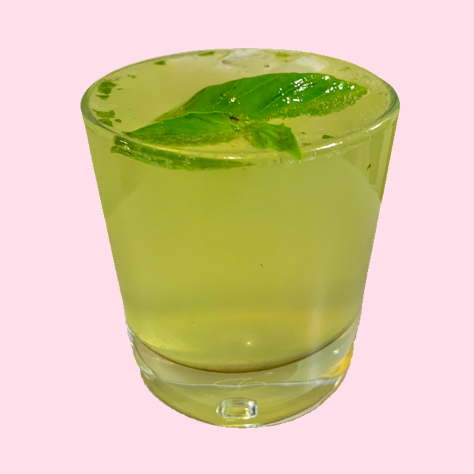 drink in a short glass with a basil garnish