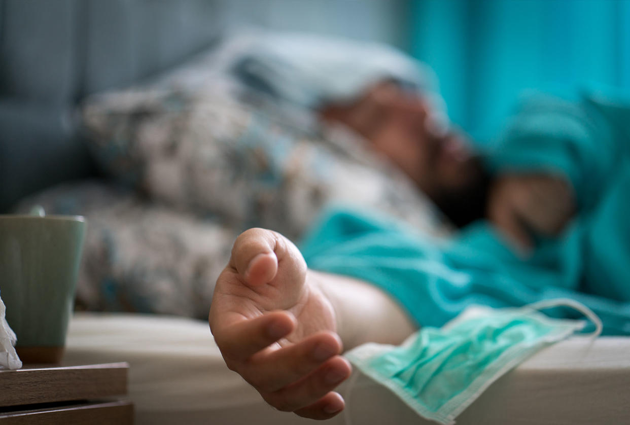 Sick man with covid-19 symptoms in bed Getty Images