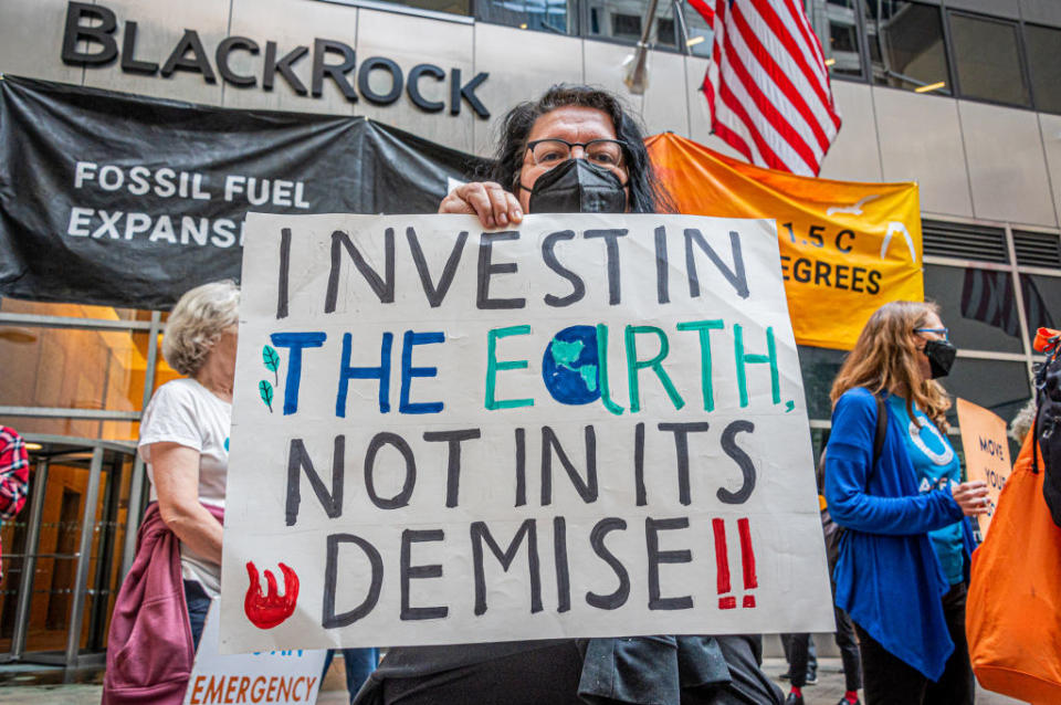 A protester at a climate change awareness rally in front of BlackRock