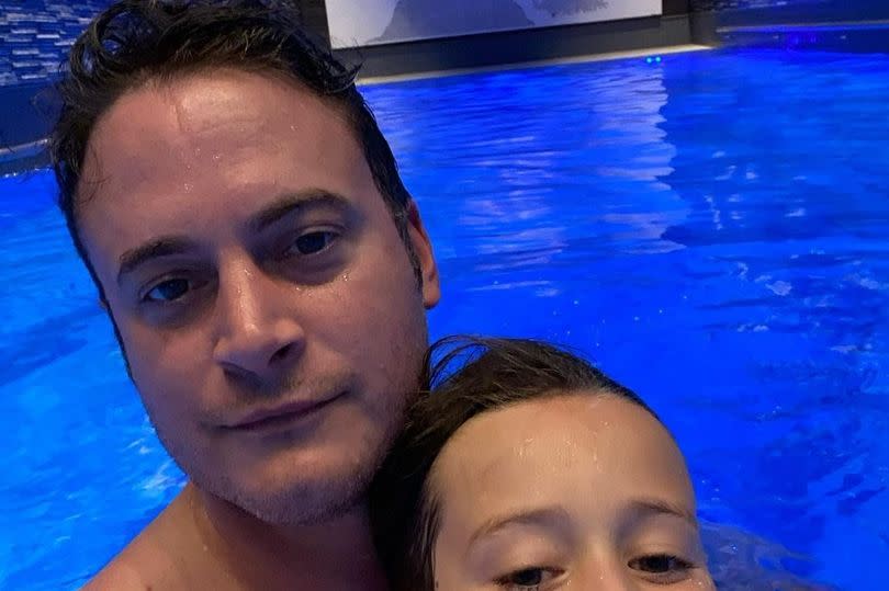 Gary Lucy in the pool with his son