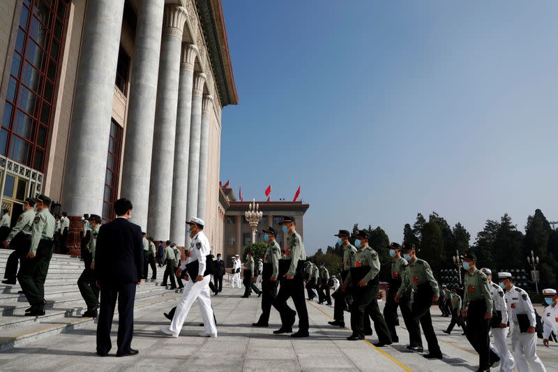 Military delegates wearing face masks following the coronavirus disease (COVID-19) outbreak, arrive to the Great Hall of the People before the opening session of the National People's Congress (NPC) in Beijing