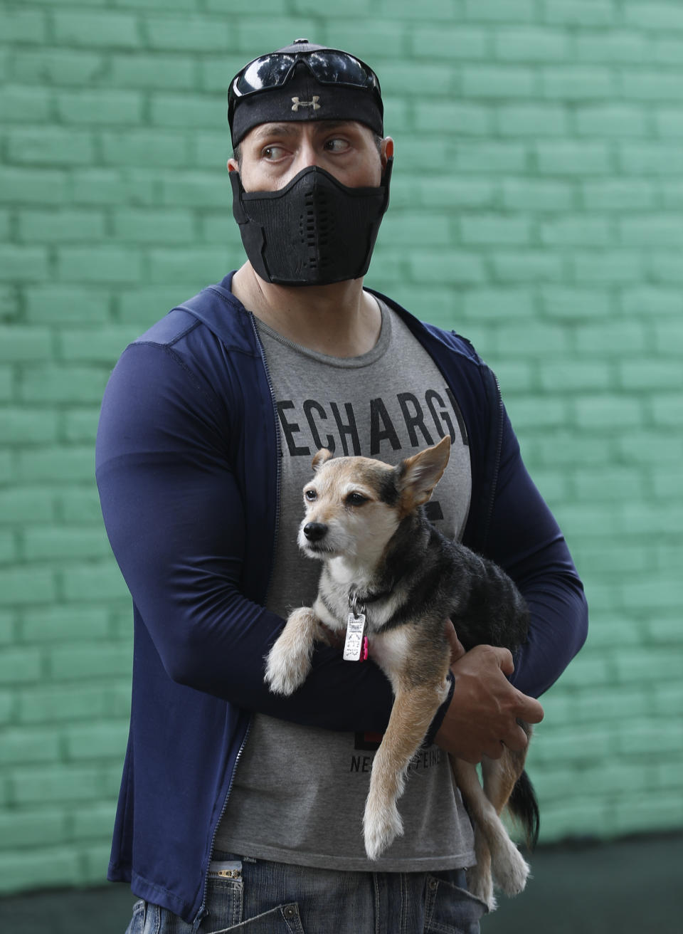 A man holds his dog as he stands outside his home while they wait for the all-clear to return to their apartment, after an earthquake in Mexico City, Tuesday, June 23, 2020. The earthquake struck near the Huatulco resort in southern Mexico on Tuesday morning, swayed buildings in Mexico City and sent thousands fleeing into the streets. (AP Photo/Eduardo Verdugo)