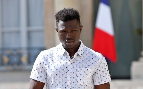 Mamoudou Gassama, 22, from Mali, leaves the presidential Elysee Palace after his meeting with French President Emmanuel Macron, in Paris, - Credit: Thibault Camus/AP