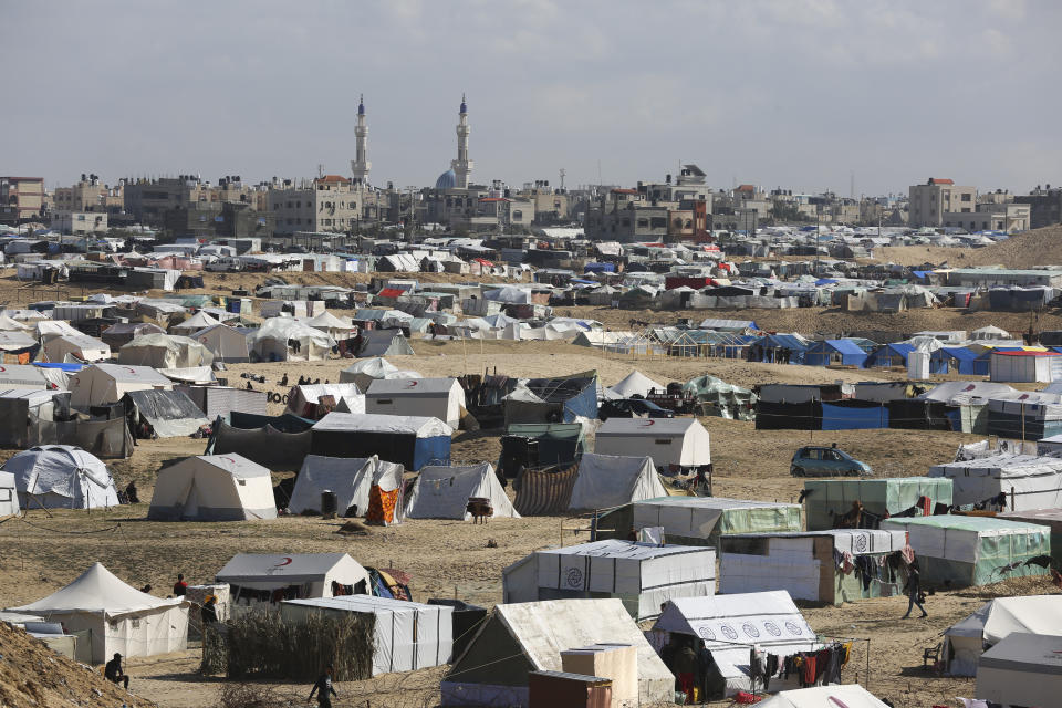 Palestinians displaced by the Israel air and ground offensive on the Gaza Striptake shelter near the border fence with Egypt in Rafah, Wednesday, Jan. 24, 2024. (AP Photo/Hatem Ali)