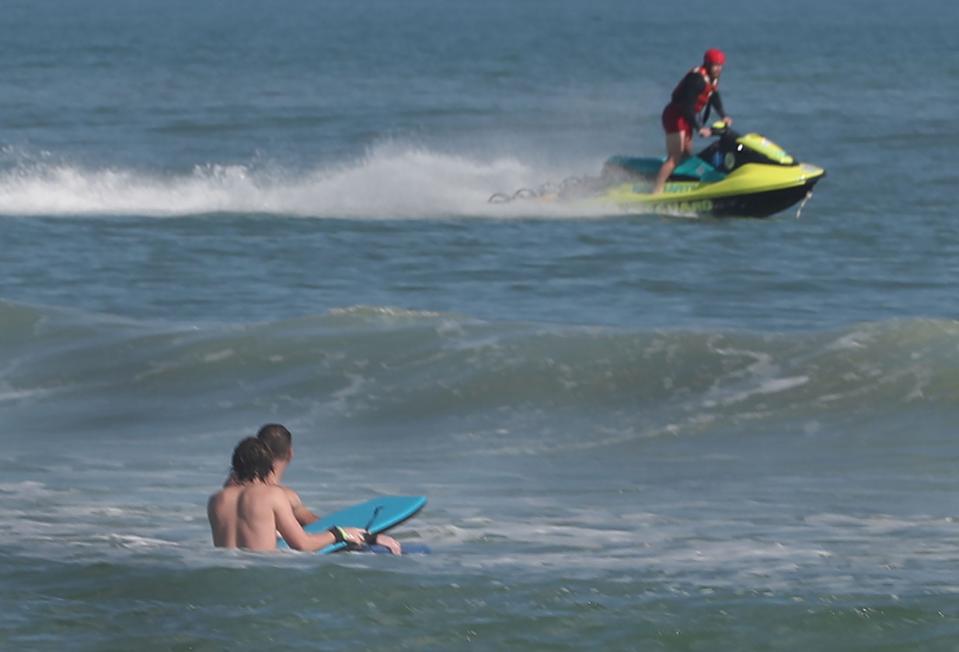 A Volusia County Beach Safety / Ocean Rescue lifeguard races south outside the breakers on a personal watercraft, Thursday February 2, 2023 in front of Andy Romano Beachfront Park in Ormond Beach