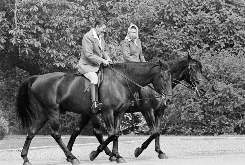 FILE - U.S. President Ronald Reagan, on Centennial, and Queen Elizabeth II, on Burmese, go horseback riding in the grounds of Windsor Castle, England, June 8, 1982. Queen Elizabeth II, Britain's longest-reigning monarch and a rock of stability across much of a turbulent century, died Thursday, Sept. 8, 2022, after 70 years on the throne. She was 96. (AP Photo/Bob Daugherty, File)