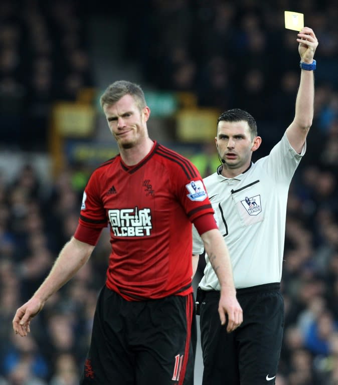 Referee Michael Oliver shows West Bromwich Albion's Chris Brunt a yellow card during their English Premier League match against Everton, at Goodison Park in Liverpool, on February 13, 2016