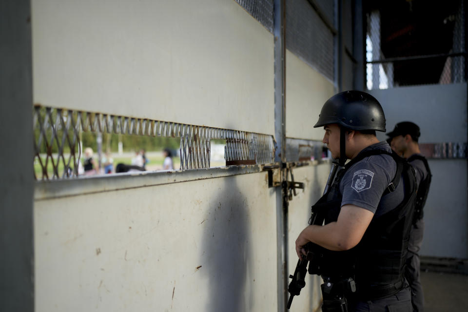 Prison guards stand behind the entrance to Pinero jail in Pinero, Argentina, Tuesday, April 9, 2024. Authorities have ramped up prison raids, seized thousands of smuggled cellphones and restricted visits. (AP Photo/Natacha Pisarenko)