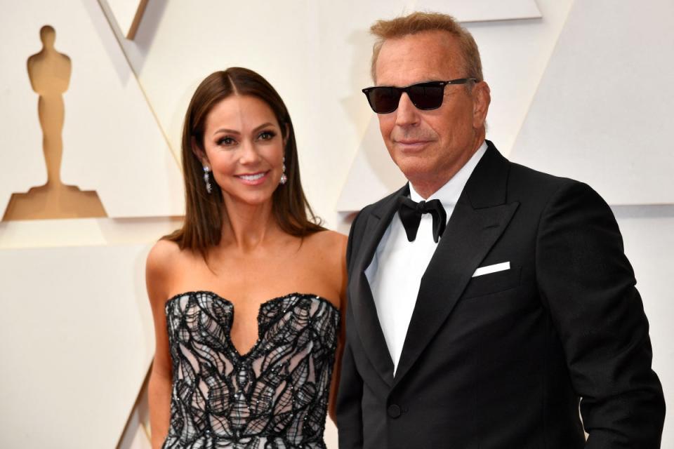 Kevin Costner and Christine Baumgartner at the Oscars in 2022 (AFP via Getty Images)