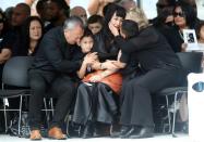 Widow of late New Zealand All Blacks rugby legend Jonah Lomu, Nadene Lomu (C) is comforted by her two sons, Brayley (C-L) and Dhyreille (C-R), her mother Lois Kuiek and father Mervyn Kuiek during memorial service on November 30, 2015