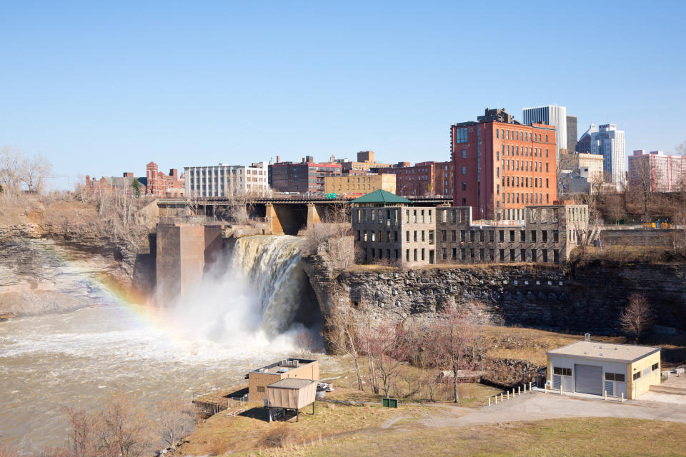 Waterfalls of Rochester, NY, USA. The waterfalls are in the foreground and buildings in the background.