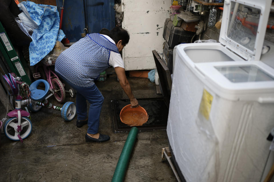 A woman scoops out a bucket of water from her tank after delivery from a water truck, in the Iztapalapa neighborhood of Mexico City, Thursday, Feb. 22, 2024. As the election approaches, a worsening water crisis is making it harder for the presidential candidates to ignore Mexico’s climate threats. (AP Photo/Eduardo Verdugo)