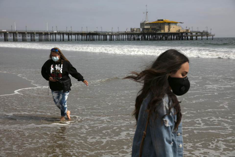 FILE - In this June 23, 2020, file photo, Malia Pena, foreground, and her mother, Lisa Torriente, wear masks as they visit the beach in Santa Monica, Calif. (AP Photo/Jae C. Hong, File)