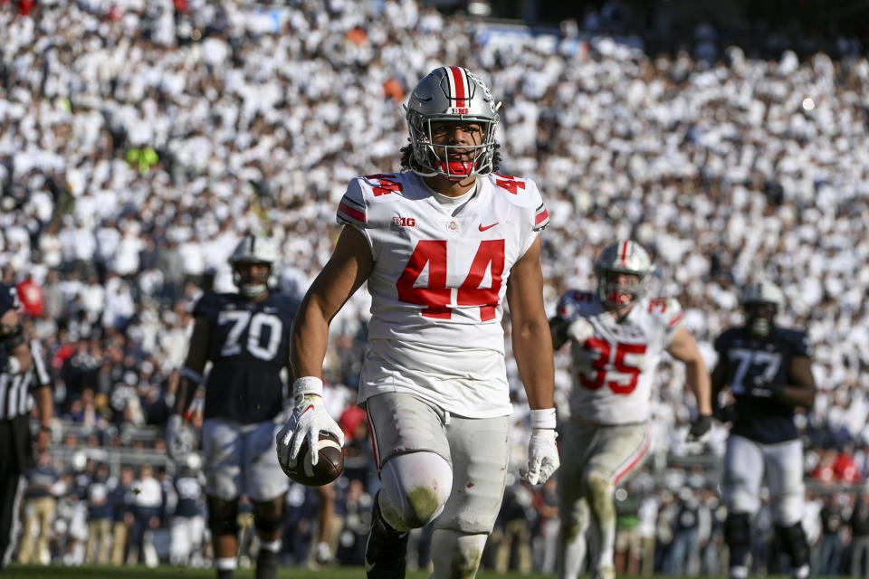 Ohio State defensive end J.T. Tuimoloau (44) returns an interception for a touchdown during the fourth quarter of an NCAA college football game against Penn State, Saturday, Oct. 29, 2022, in State College, Pa. Ohio State won 44-31. (AP Photo/Barry Reeger)