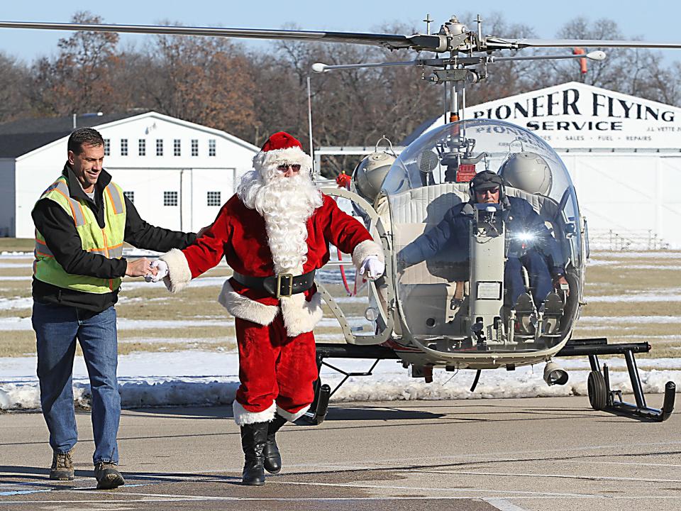 Santa Claus emerges from a helicopter to the waiting guest at the EAA's Christmas in the Air Saturday.