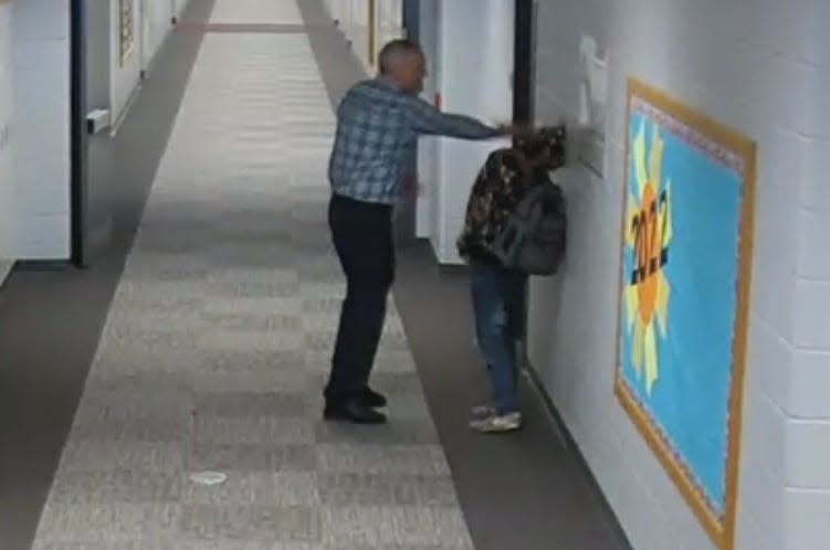 A screen grab from security camera footage shows Jimtown High School teacher Mike Hosinski striking a student in the head, against a wall, on Friday morning, Feb. 25, 2022. 