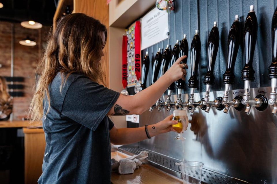 Woman pours beer on tap