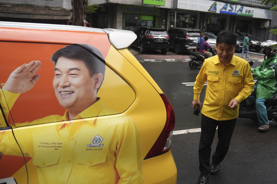 Chong Sung Kim, a Golongan Karya party legislative candidate, walks toward his campaign car in Jakarta, Indonesia, Tuesday, Jan. 30, 2024. As Indonesia votes this month to replace popular President Joko Widodo, all three candidates have all been aggressively seeking to win the votes of younger people, reaching out to them on the apps they use, through the K-pop music many love, and even video gaming events. (AP Photo/Dita Alangkara)