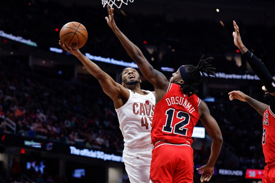 Cleveland Cavaliers guard Donovan Mitchell (45) shoots against Chicago Bulls guard Ayo Dosunmu (12) during the second half of an NBA basketball game, Saturday, Feb. 11, 2023, in Cleveland. (AP Photo/Ron Schwane)