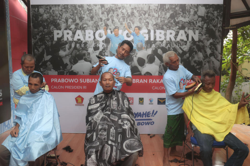 Supporters of presidential candidate Prabowo Subianto and his running mate Gibran Rakabuming Raka, the eldest son of Indonesian President Joko Widodo, have their head shaven to celebrate the former general's lead in the unofficial vote count of the presidential election, Surabaya, Indonesia, Wednesday, Feb. 14, 2024. Defense Minister Prabowo Subianto held a commanding lead in early, unofficial tallies of Indonesia's presidential race Wednesday, potentially putting the former general on a path to claim victory in a three-way race to lead the world's third-largest democracy. (AP Photo/Trisnadi)