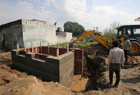 Workers construct a concrete bunker in a residential area near the border with Pakistan in Samba sector near Jammu February 26, 2019. REUTERS/Mukesh Gupta