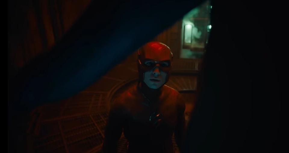 The Flash examines a costume in a futuristic room