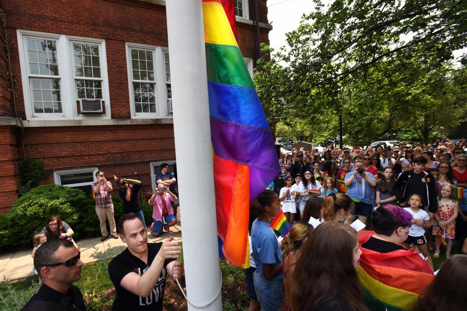 Brett Essenter, a founding member of the Rutherford Pride Alliance, raises a rainbow flag for LGBT pride at Rutherford Borough Hall in New Jersey on June 1, 2019.