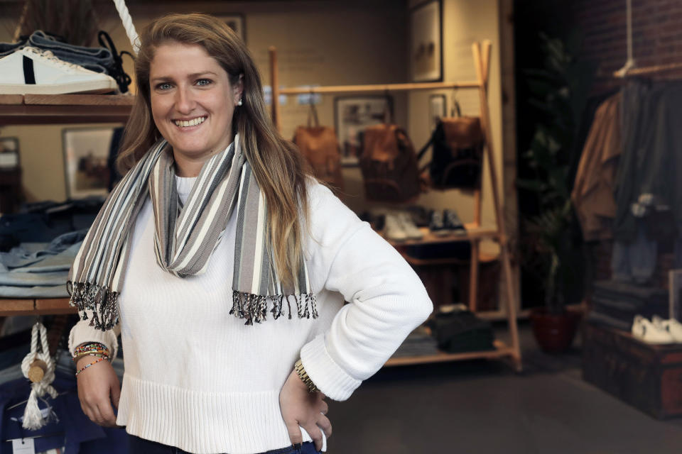 In this Thursday, Nov. 14, 2019, photo, Annie Venditti, vice president of operations at clothing retailer American Rhino, stands for a photograph in the store, in Faneuil Hall Marketplace, in Boston. At the age of 23, Venditti was learning about the complexities of building and liquor laws. The company did the smart thing, and got a consultant to guide them. (AP Photo/Steven Senne)