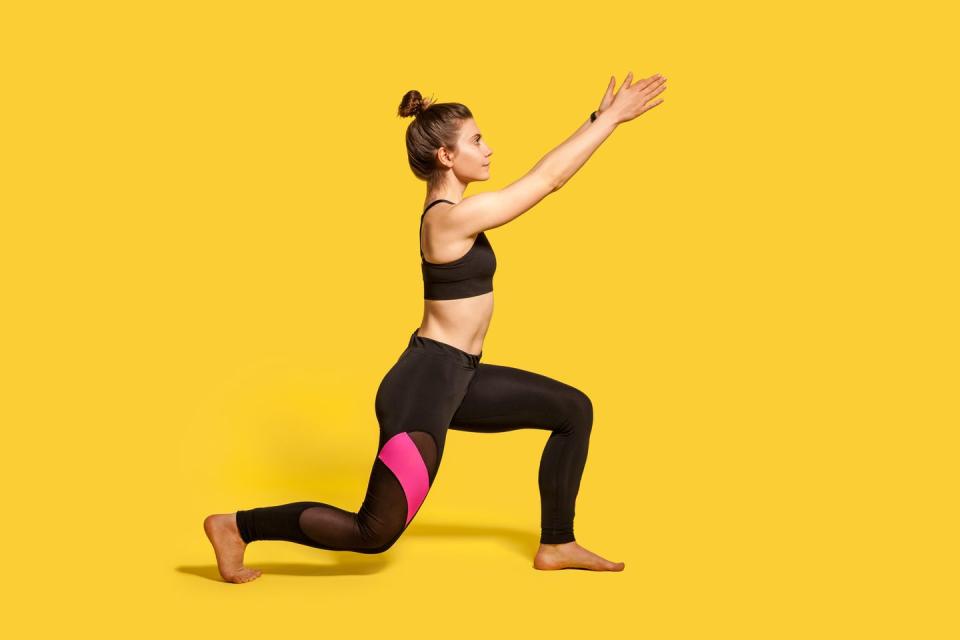 side view, slim young woman with hair bun in tight sportswear doing sport lunge exercise, standing one knee