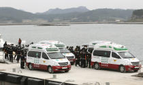 Emergency workers carry the bodies of passengers aboard the Sewol ferry which sank in the water off the southern coast, upon their arrival at a port in Jindo, South Korea, Tuesday, April 22, 2014. As divers continue to search the interior of the sunken ferry, the number of confirmed deaths has risen, with over 200 other people still missing. (AP Photo/Ahn Young-joon)