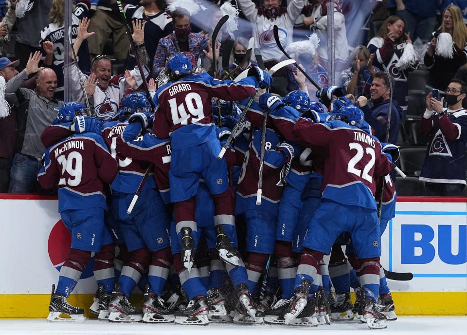 Colorado Avalanche players congratulate Mikko Rantanen after his overtime goal against the Vegas Golden Knights during Game 2 of an NHL hockey Stanley Cup second-round playoff series Wednesday, June 2, 2021, in Denver. (AP Photo/Jack Dempsey)