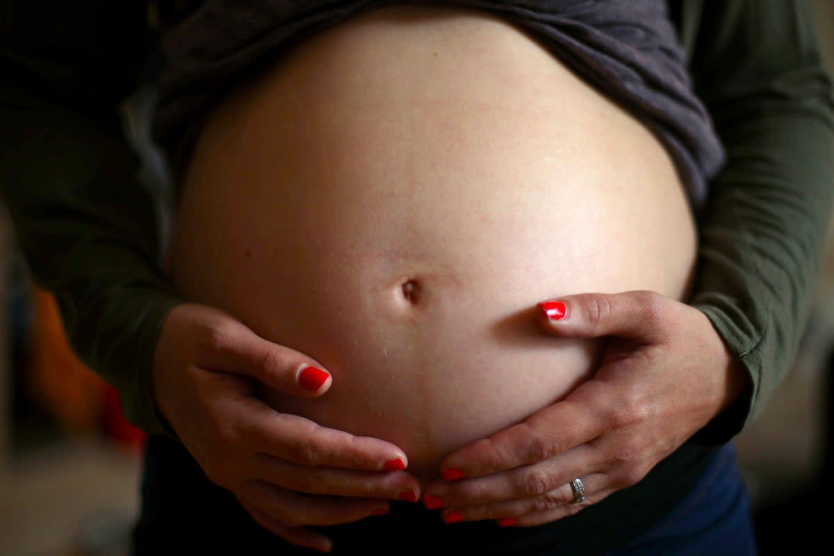 File photo dated 25/05/18 of a pregnant woman holding her stomach. (PA Wire)