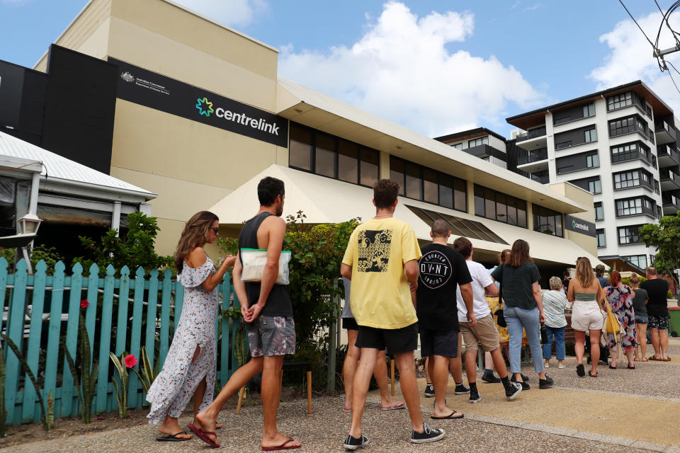 GOLD COAST, AUSTRALIA - MARCH 23: People queue outside Centrelink in Pam Beach on March 23, 2020 in Gold Coast, Australia. From midday Monday, venues such as bars, clubs, nightclubs, cinemas, gyms and restaurants, along with anywhere people remain static would be closed. Schools remain open but parents have the option to keep children at home if they wish while Victoria is bringing forward school holidays from Tuesday. There are now 1353 confirmed cases of COVID-19 In Australia and the death toll now stands at seven. (Photo by Chris Hyde/Getty Images)