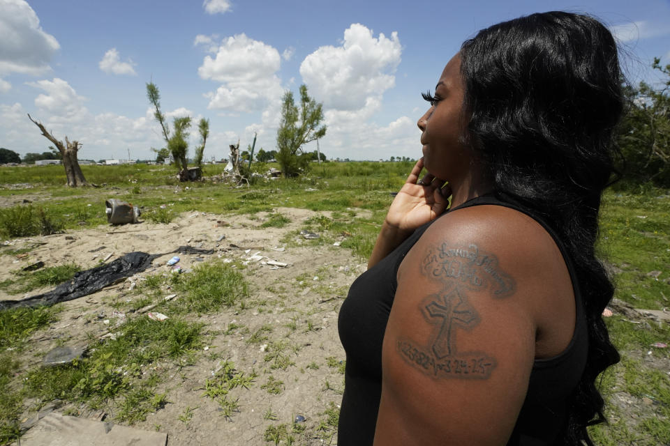 Queen'terica Jones looks at a vacant lot on May 19, 2023 in Rolling Fork, Miss., where she lived with her mother, Erica “Nikki” Moore, and three children in a mobile home before a devastating tornado stuck in March. On the evening of the tornado, she found her mother’s lifeless body facedown amid the rubble. Jones wears a memory tattoo on her shoulder honoring her mother. (AP Photo/Rogelio V. Solis)