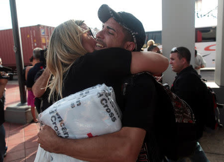 A woman hugs a man who arrived along with other refugees onboard the Royal Caribbean's Majesty of the Seas cruise ship from St. Thomas, U.S. Virgin Islands, in San Juan, Puerto Rico September 14, 2017. REUTERS/Alvin Baez